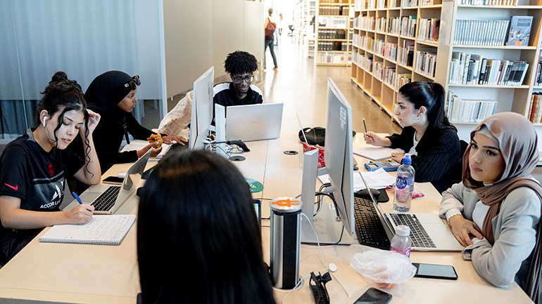 Studenter sitter runt ett bord