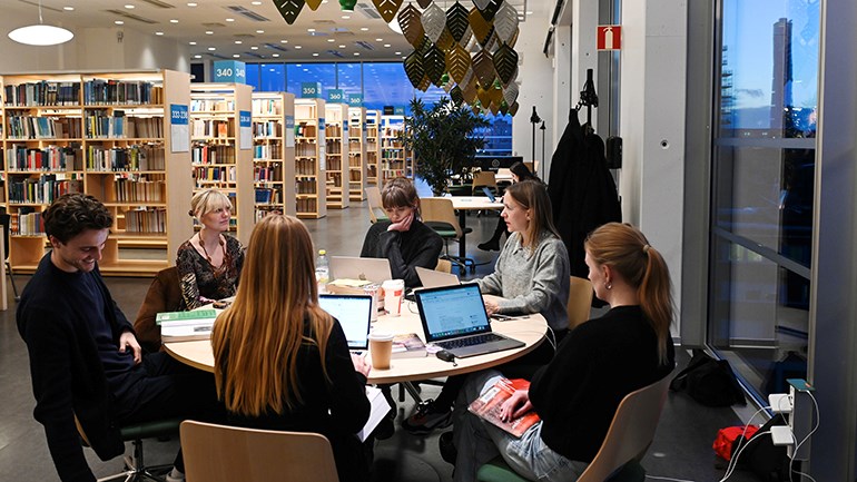 Studenter runt bord i Orkanenbiblioteket