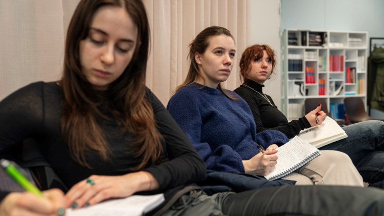 A student takes notes during a lecture.