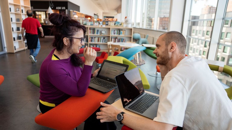 Studenter sitter i biblioteket.