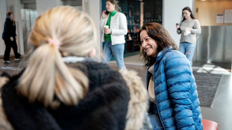 Studenter pratar vid biblioteket