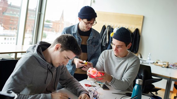 Tre studenter samarbetar.