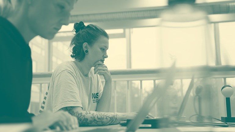 Students sitting in front of a computer.