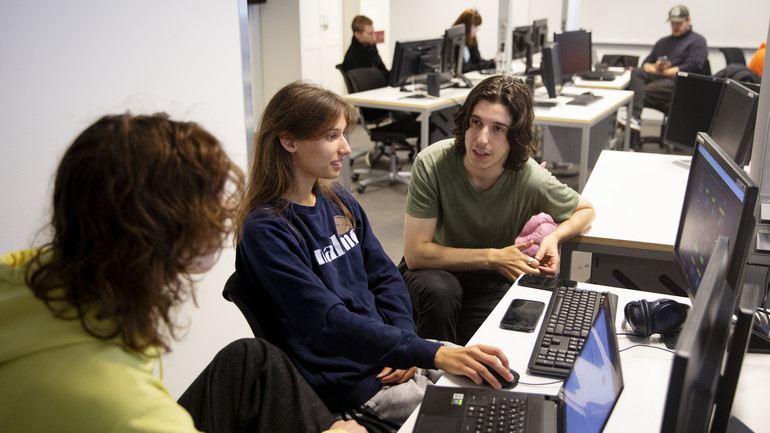 Studenter samarbetar vid datorer