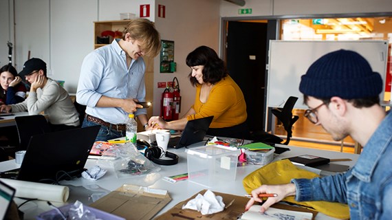 Studenter samarbetar vid projektbord.