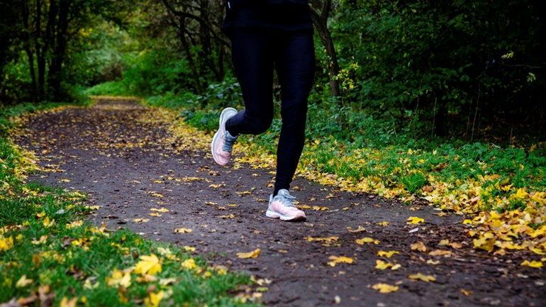 A woman is running through the forest.
