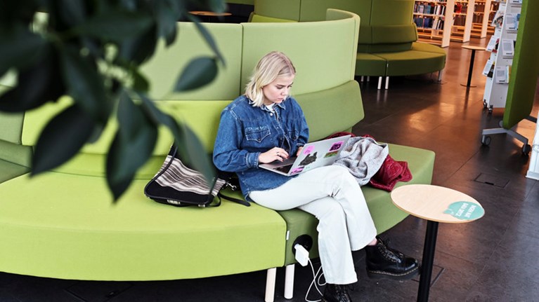 Student med dator i orkanenbiblioteket.