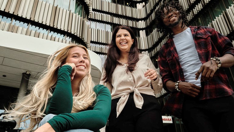 Studenter utanför en av universitetets byggnader.