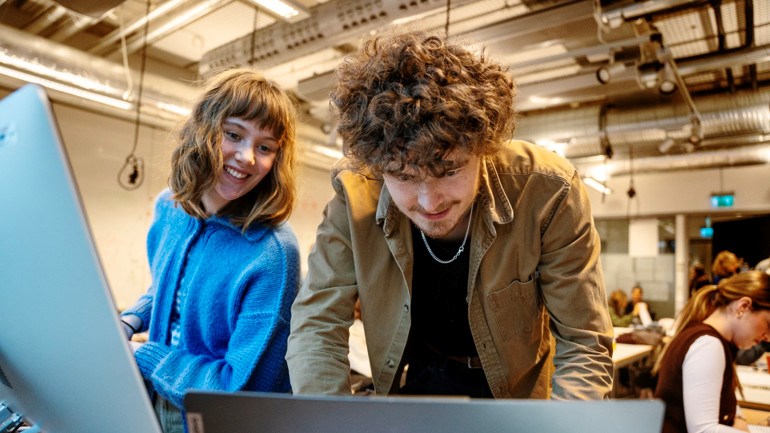 Två studenter framför datorer